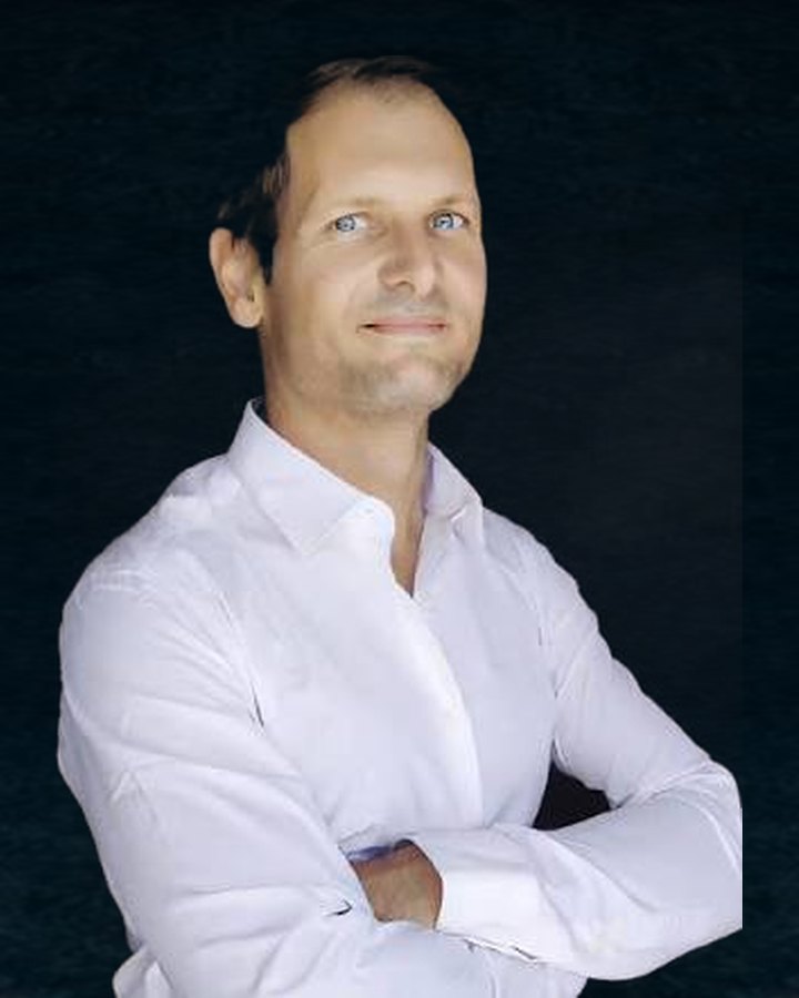 Benjamin Duplaa, chemise blanche, bras croisés, regard levé, sur un fond bleu nuit texturé